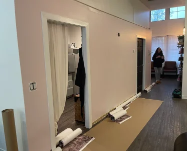 Large white sheet covering a wall with two people in the room.
